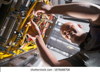 Close up of a technician checking the wires in the data center