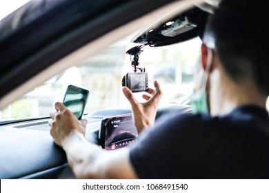 Close up Technician Hand with Car Camera and Smartphone Inside Car and Blur Man as a Foreground - Shutterstock ID 1068491540