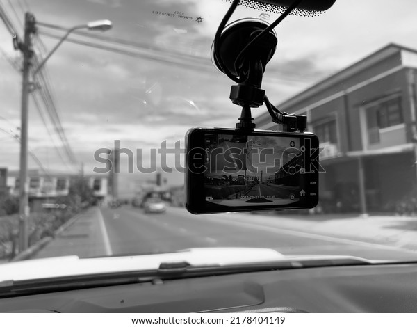 Close up Technician Hand with Car Camera and\
Smartphone Inside Car on the road side , black and white tone, 15\
July 2022, Buriram\
province.