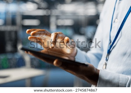 Close up of technician in server hub doing AI machine learning automatization. Data center software engineer using tablet for hardware maintenance with artificial intelligence support.