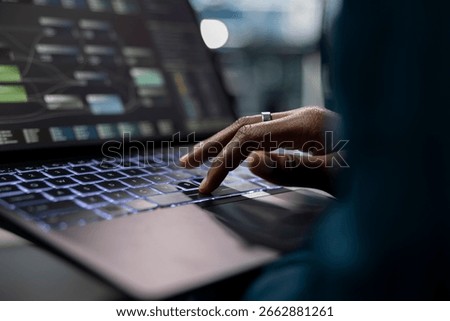 Close up of technician using laptop to do programming in server farm housing infrastructure storing datasets. IT specialist typing on notebook keyboard, coding, repairing data center racks