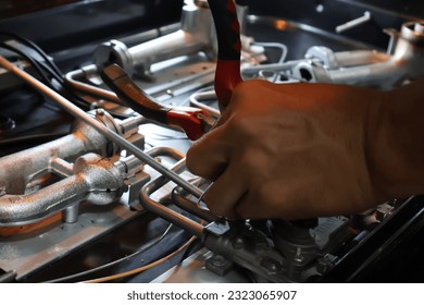 Close up of a technician's hand repairing a broken cooktop or stovetop