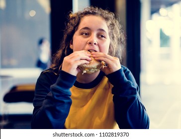Close up of teenage girl eating hamburger obesity concept - Shutterstock ID 1102819370