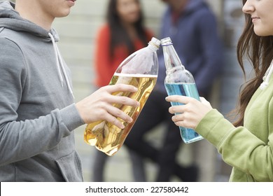 Close Up Of Teenage Group Drinking Alcohol Together