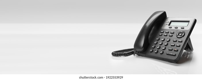 Close up telephone devices at office desk for customer service support with B2B service technology concept. telephone with VOIP. banner with copy space - Shutterstock ID 1922553929
