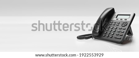Close up telephone devices at office desk for customer service support with B2B service technology concept. telephone with VOIP. banner with copy space