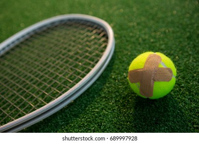 Close up of tennis ball with bandage by racket on field - Powered by Shutterstock