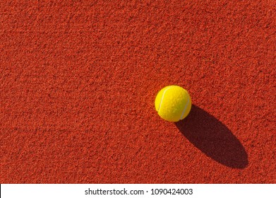 Close up of a tennis ball on a red surface of a clay court. - Powered by Shutterstock
