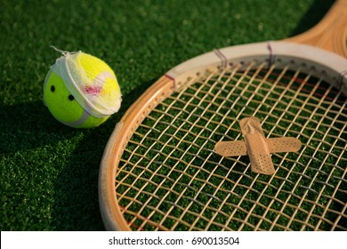 Close up of tennis ball and racket with bandage on field - Powered by Shutterstock