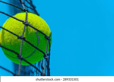 Close Up Of Tennis Ball Stuck On The Net