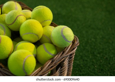 Close up of tennis balls in wicker basket on field - Powered by Shutterstock