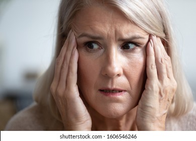 Close Up Of Terrified Mature Woman Look In Distance Thinking Remembering, Scared Senior Female Retiree Grandmother Feel Scared Frightened, Face Strong Fear Or Anxiety At Home, Having Panic Attack