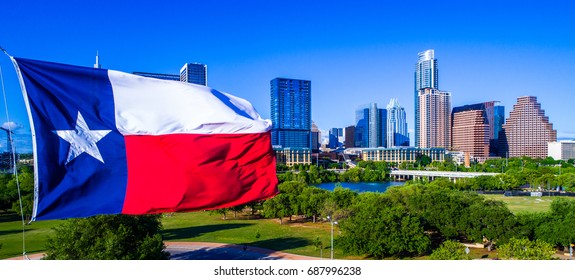 Close up of Texas Flag patriotic National Pride Displays the Lone Star State with a Colorful Austin Texas Skyline Cityscape Capital Cities Background on a Nice Sunny Summer Blue Sky Day