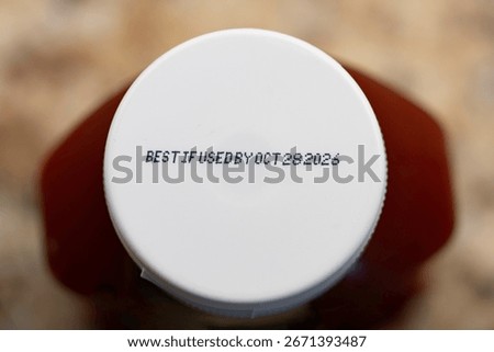 Close up text best before date on food bottle cap.