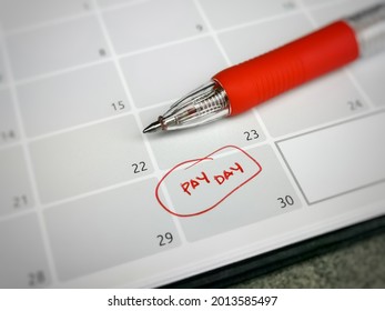 Close Up Text Pay Day Written On Calendar With A Pen. Reminder Concept Of Payment. Selective Focus.