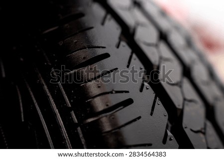 Close up texture of deep tread pattern on new black rubber tyre of agricultural machinery.