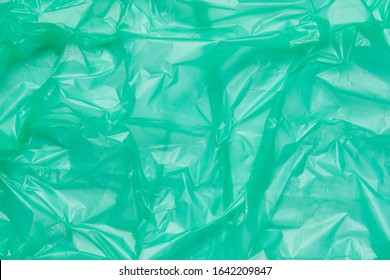 Close Up Texture Of A Green Plastic Garbage Bag. Green Polyethylene Film. Texture Of Cellophane