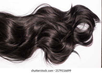 The close up of the texture of the shiny black human curly hair isolated on the white background - Shutterstock ID 2179116699
