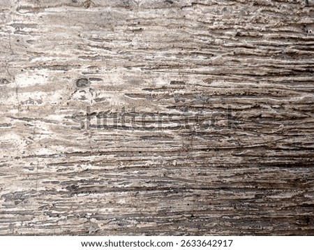 Close up texture of a weathered and aged stone surface with natural horizontal striations and earthy tones. Ideal for use as a background or texture in design projects, offering a rustic and aesthetic