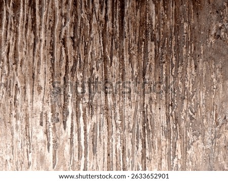 Close up texture of a weathered and aged stone surface with natural vertical striations and earthy tones. Ideal for use as a background or texture in design projects, offering a rustic and aesthetic