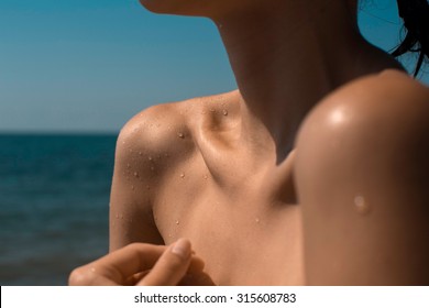 Close Up Texture Of The Wet Shoulder Of A Young Woman Showing Skin Detail And The Way The Water Condenses 