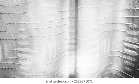 Close up textured, embroidered pattern. The design features  geometric shapes and lines, creating a modern and abstract appearance. The fabric appears to be part of a curtain.