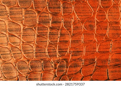 Close up of textured orange material with repeating scales.