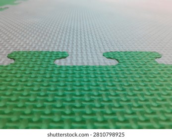 Close up of the textured surface of interlocking foam puzzle mats used in children's play areas. Showcasing soft EVA foam material, interlocking edges, and a safe cushioned surface ideal for playrooms, daycare centers, schools, fitness spaces, and indoor recreation.