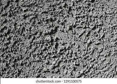 Close up of Textured Wall Plaster or Stucco of Drywall on Building in Hard Light