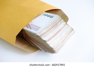 Close up of Thai money with one thousand baht banknotes in paper bag on white background, copy space and selective focus. - Shutterstock ID 682917892