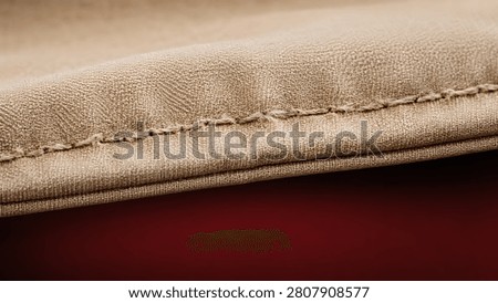 Close up of thick stitched leather edge, representing a preventive maintenance warning regarding the inspection of seam integrity and material wear in heavy-duty upholstery