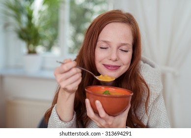 Close up Thoughtful Young Woman Eating Healthy Soup at Home with Eyes Close and Happy Facial Expression.