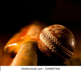 Close Up Of A Thrashed And Worn Out Cricket Ball (season Ball) Next To A Cricket Bat On Wood. 