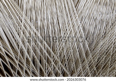 Close up of a lot of threads in a weaving machine called a loom