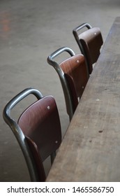 close up of three chairs in a row at rustic wooden table