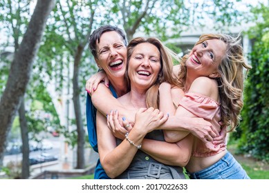 Close Up Of Three Cheerful Mature Female Friends Hugging Together