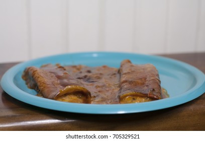 Close Up Of Three Cheese Enchiladas On A Pretty Blue Plate