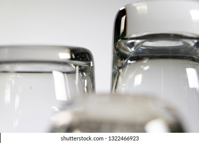 Close up of three empty shot glasses on white background.