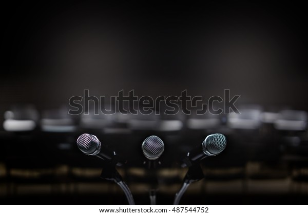 Close up of three microphone in meeting room\
or conference room blur\
background.