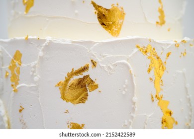 Close Up Of A Three Tier Wedding Cake With Gold Leaf