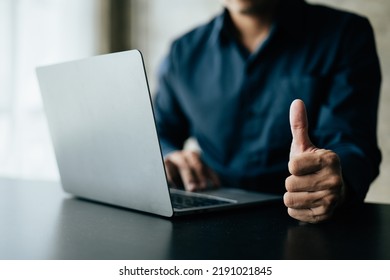 Close up of thumbs up and working on laptop. - Shutterstock ID 2191021845