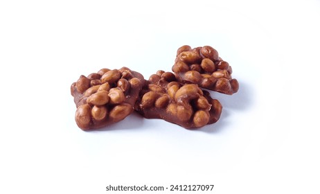 Close up of Ting-ting or Enting-enting or Ampyang isolated on white background. Traditional Indonesian sweet snack made from peanuts mixed with brown sugar. Clipping path. 