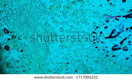 Close up of tiny bacteria under the microscope, scientific background. Stock footage. Infection, medicine, and biology concept, microorganisms and microbes on blue liquid background.