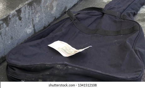 Close Up For Tips Lying On Black Guitar Case On Grey Pavement Background. Russian Paper Money Lying On Empty, Black Guitar Bag, Street Music Concept.