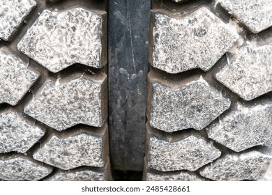 Close up of a tire of an excavator on wheels at a construction site. Rough tire tread design. - Powered by Shutterstock