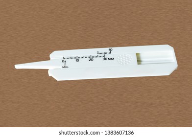 Close Up Of Tire Tread Depth Gauge Isolated On Wooden Background.