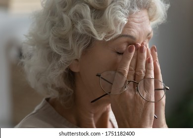 Close Up Of Tired Elderly Woman Rub Massage Eyes Take Off Glasses Suffering From Headache Or Migraine, Exhausted Mature 60s Female Have Dizziness Or Blurry Vision Form High Blood Pressure