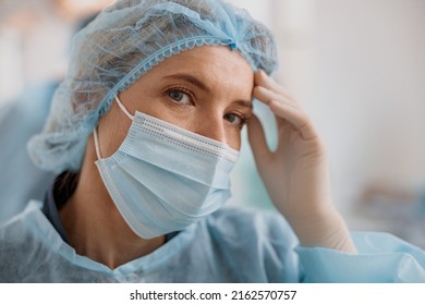 Close Up Of Tired Surgeon In Mask Standing In Operating Room After Major Surgery