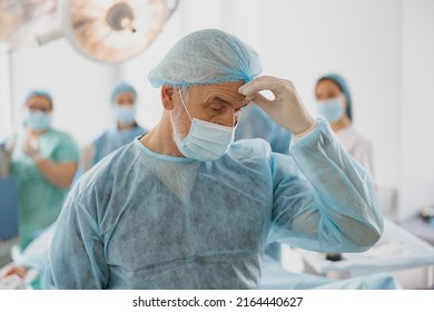 Close Up Of Tired Surgeon In Mask Standing In Operating Room After Hard Unsuccessful Operation