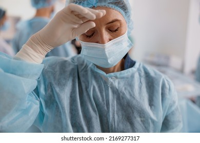 Close Up Of Tired Surgeon In Mask Standing In Operating Room After Major Surgery